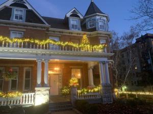 a house decorated with christmas lights and a christmas tree at The Secret Garden Inn in Kingston