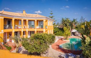a yellow house with a swimming pool in front of it at Moonshine Studios Lagos in Lagos