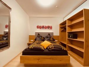 een slaapkamer met een bed met een spiegel en planken bij Apartment Mitterberger - Nassfeld in Tröpolach
