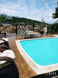 una piscina en una terraza con mesa y sillas en SOL&MAR Suítes Ilhabela, en Ilhabela