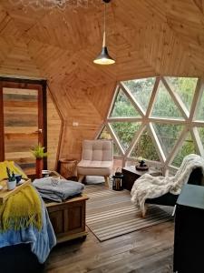 a room with two beds and a chair in a cabin at Glamping Cantabria in Tunja