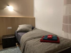 uma cama com um chapéu vermelho em cima em Renthouse Guest Apartment em Paide