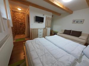 um quarto com uma grande cama branca e um sofá em Chalupa Krkonoše em Cerný Dul