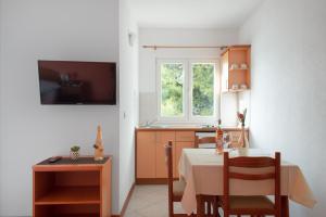 a kitchen and dining room with a table and a window at Promenada - Beachfront Apartments in Tučepi