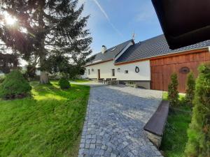 a church with a stone path in front of a building at Chalupa Chlum Míša in Volary