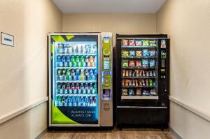 a soda machine in a room next to a refrigerator at WoodSpring Suites Dallas Rockwall in Rockwall