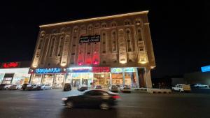 a car driving in front of a building at night at هبي نيس للوحدات السكنية in Al Madinah
