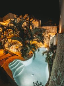 a swimming pool with palm trees in it at night at Pacha Tulum in Tulum