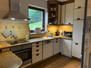 a kitchen with white cabinets and a sink and a window at Winterberger Lodge in Winterberg