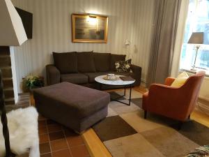 a living room with a couch and a table at Nya Pallas Hotel in Falkenberg