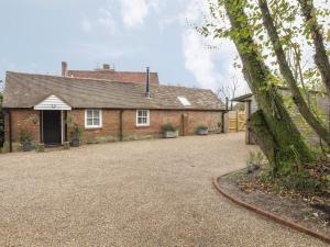 een stenen huis met een oprit ervoor bij Stables Cottage in Heathfield