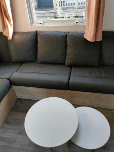 two white tables in front of a couch at Holiday in Renesse in Renesse