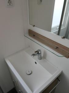 a bathroom with a white sink and a mirror at Holiday in Renesse in Renesse