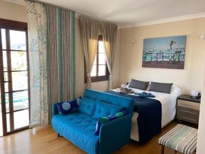 a bedroom with a bed and a blue couch at Dream View in Adeje