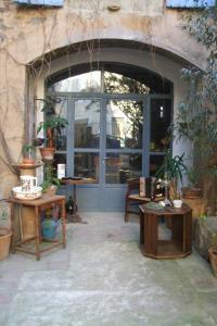 OlonzacにあるLa Vigne Bleueのパティオ(テーブル2台、大きな窓付)