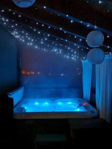 eine blaue Badewanne in einem Zimmer mit Licht in der Unterkunft Apartment Viksa with Jacuzzi in Zagreb