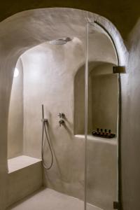 a shower with a glass door in a bathroom at Enigma Suites in Fira