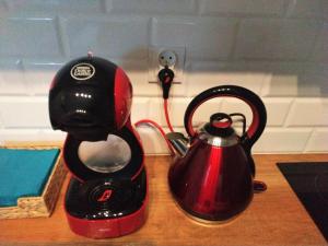 a red and black tea kettle sitting on a counter at theApartments Radwańska in Łódź