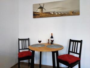 une table avec deux chaises, un verre à vin et un moulin à vent dans l'établissement theApartments Radwańska, à Łódź