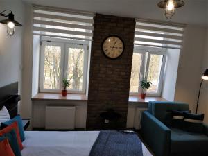 une pièce avec deux fenêtres et une horloge sur un mur de briques dans l'établissement theApartments Radwańska, à Łódź 50 autres photos