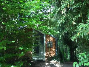 ein Haus mit einer Glastür inmitten von Bäumen in der Unterkunft Palazzo delle Biscie - Old Tower & Village in Molinella