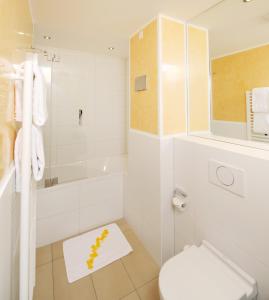 ein weißes Bad mit einem WC und einer Badewanne in der Unterkunft GuestHouse Mainz in Mainz