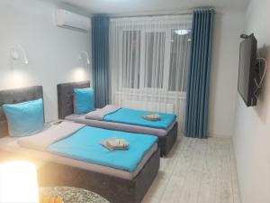 - 2 lits dans une chambre avec fenêtre dans l'établissement Апартаменты Weekend Inn, à Oujhorod