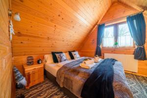 a bedroom with a bed in a log cabin at Domki Widokowe Wooden Pod Gubałówką z Jacuzzi in Ząb