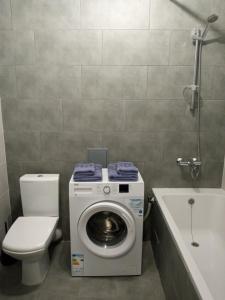ein Badezimmer mit einer Waschmaschine und einem WC in der Unterkunft Апартаменты Weekend Inn in Uschhorod