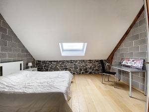 a attic bedroom with a bed and a desk at Classy Holiday Home in Achet with Garden 