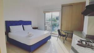 a bedroom with a bed and a table and a window at Apartahotel Plaza de ángel 74 in Barranquilla