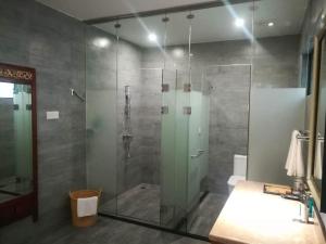 a shower with a glass door in a bathroom at Guilin Crystal Crescent Moon Hotel in Guilin