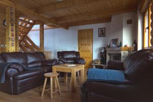 a living room with black leather furniture and a fireplace at Kiwi Chalet in Kupres
