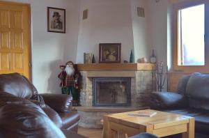 a living room with a doll standing next to a fireplace at Kiwi Chalet in Kupres