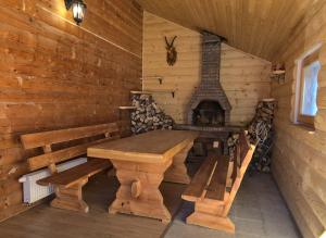 a wooden room with a table and a fireplace at Kiwi Chalet in Kupres