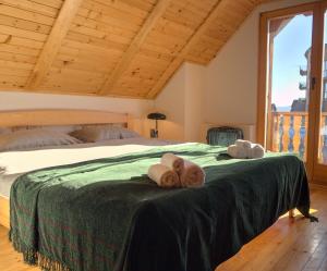 a bedroom with a bed with two towels on it at Kiwi Chalet in Kupres +10 photos