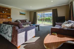 sala de estar con sofá y mesa en Leigh Cottage Manapouri, en Manapouri