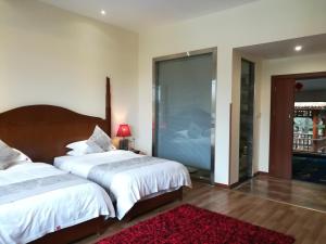 a bedroom with two beds and a red rug at Guilin Crystal Crescent Moon Hotel in Guilin
