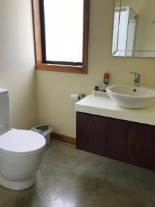 a bathroom with a toilet and a sink at Pilgrims Rest in Miranda
