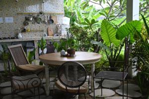 a table and chairs in a room with plants at Villa Lotus 8 in Canggu
