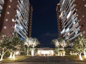 Residencial Portal da Barra في ريو دي جانيرو: منظر على مبنيين طويلين في الليل