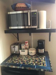 une cuisine avec un four micro-ondes et d'autres articles sur une étagère dans l'établissement Yuli's Home, à Miami