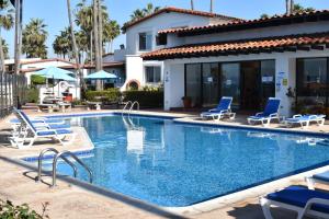 una piscina con sedie e una casa di La Paloma Beach&Tennis Resort a Rosarito