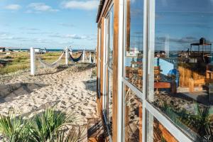 a room with a view of the beach and a hammock at Puertas al Cabo in Cabo Polonio