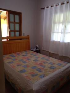 ein Schlafzimmer mit einem Bett mit einer Decke darauf in der Unterkunft Sítio Elias in Lauro Müller