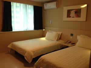 a hotel room with two beds and a window at Jinjiang Inn - Shanghai Changning in Shanghai