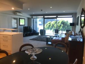 uma sala de estar com uma mesa e uma sala de estar em Picton Waterfront Oxley's Luxury Apartment em Picton