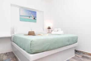 a white bedroom with a bed with green sheets at Depis Luxury Suites in Naxos Chora
