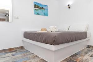 ナクソス・コラにあるDepis Luxury Suitesの白いベッドルーム(ベッド1台付)