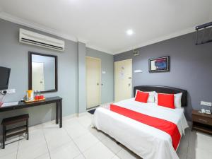 a bedroom with a large bed with red pillows at Puteri Ampang Hotel in Ampang